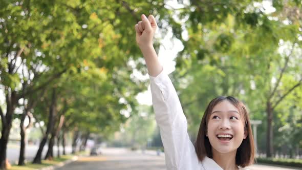 Girl standing with her hands raised indicates success.