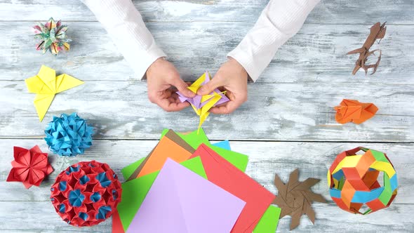 Male Hands Folding Origami Toy. alt