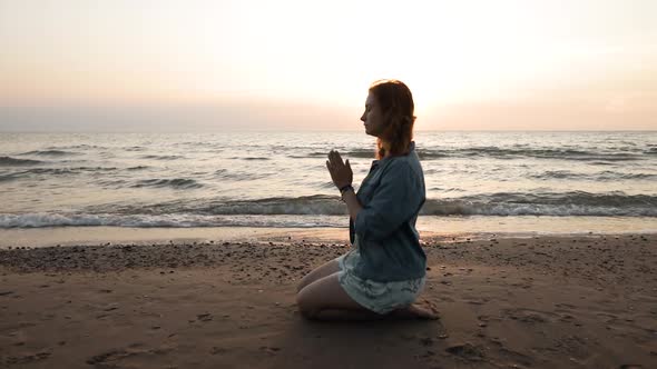 Young Woman Wears Rainbow Bracelet and Prays for LGBT Equal Rights at Sea alt