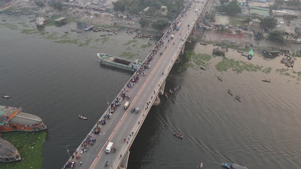 Aerial view of traffic on a bridge at Old Dhaka steamer ghat with cars and ships crossing along Buri alt