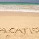 VACATION written in the beach sand washed aways by waves. - VideoHive Item for Sale
