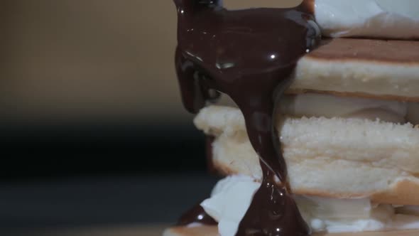 Close-up of Cooking pancake. cook pours hot chocolate syrup over dessert