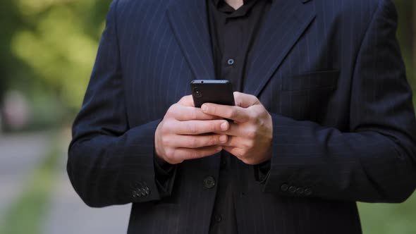 Close Up Male Hands Unknown Man in Black Formal Suit Hold Smartphone Chatting in Social Media Use alt