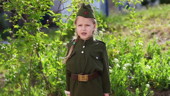 A little girl in military uniform reads poem . Holiday victory Day,  May 9.