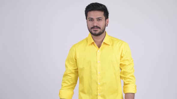 Portrait of Young Handsome Bearded Indian Businessman with Fist Raised alt