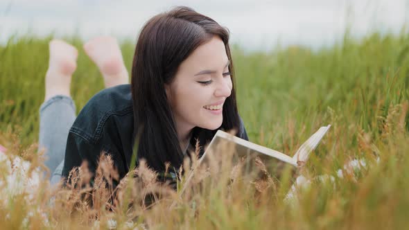 Young Attractive Brunette Caucasian Woman Girl Lying on Grass Pretty Teenage Girlfriend Student Read alt