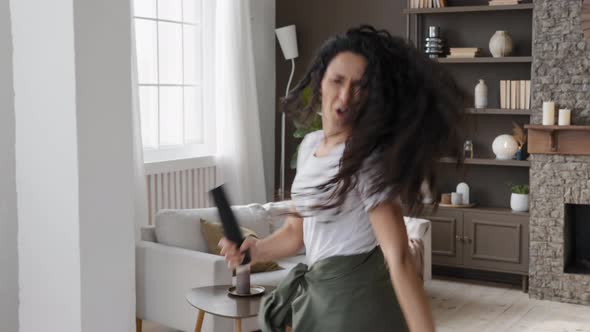 Active Funny Young Woman Looking at Camera Excitedly Singing Song Holding Tv Remote As Microphone alt