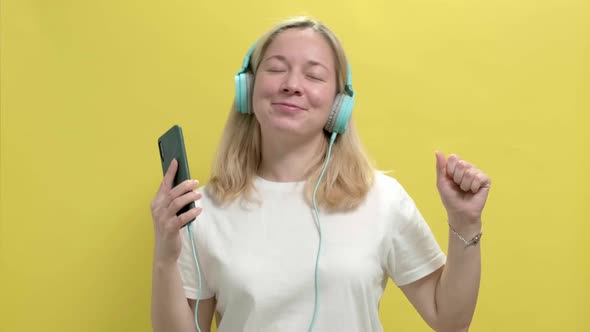 Beautiful Young Woman in a White Tshirt Listen Music in Headphones alt