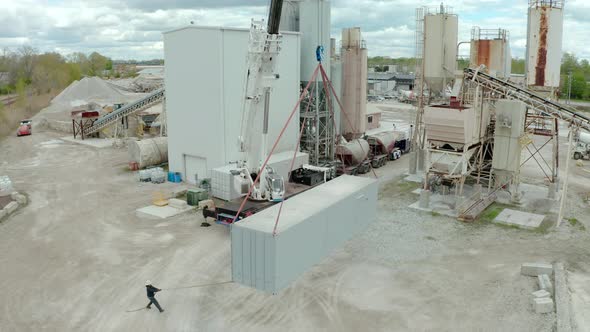 Aerial Drone View of Crane Unloads the Carrier's Truck at the Factory alt