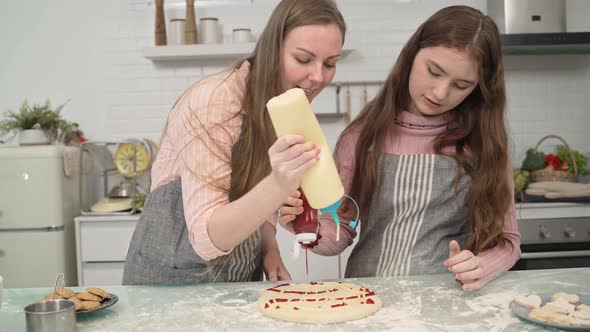 Happy mother and daughter enjoy decorating on pizza