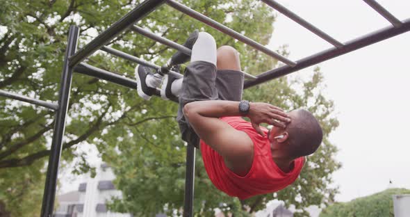 Side view man with prosthetic leg doing abs suspended in the air alt