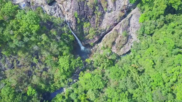 Drone Moves To High Waterfall Among Rocks in Jungle alt