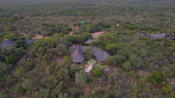 Luxurious African rural lodge with pool  in middle of bush in green savannah. Aerial view alt