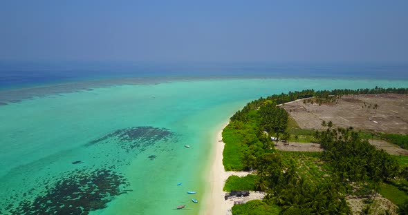 Wide aerial island view of a white sand paradise beach and aqua turquoise water background in high r alt