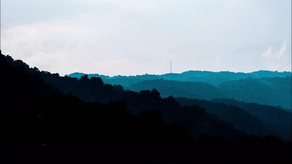 Time lapse beautiful nature of blue sky and clouds at sunrise with silhouettes of mountains. alt