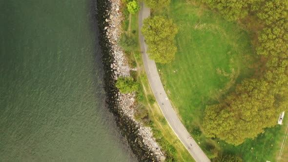 A top down shot over the stoney shores of the East River near the Throgs Neck Bridge. It is a cloudy alt