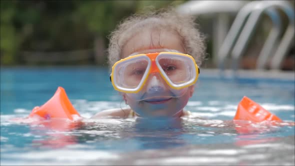 Portrait Little Girl in an Underwater Mask Floating in an Outdoor pool.Active Rest in the Water Park alt
