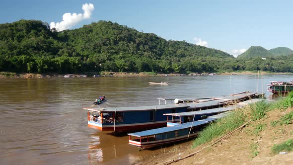 Local people leaving with a long-tail boat at the mekong river in Luang Prabang alt