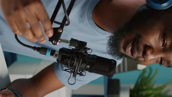 Vertical Video Close Up of Vlogger Using Microphone and Headphones alt