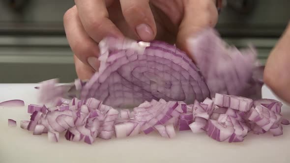 The proper way to dice a red onion with a knife! It's a satisfying close up of perfectly chopped red alt