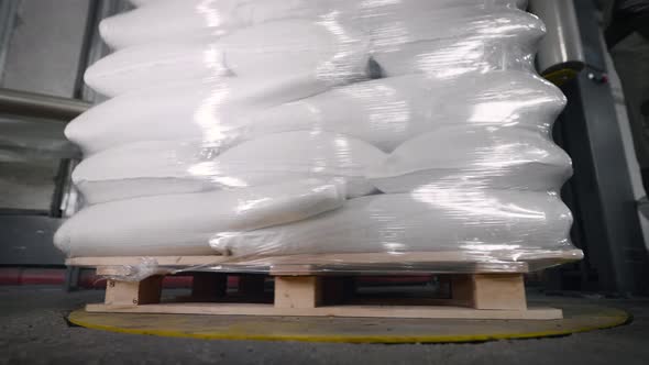 A Pallet with Bags is Packed in Foil Using a Special Machine alt