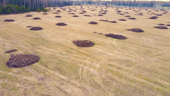 Flying Over Round Piles of Manure in an Agricultural Field alt