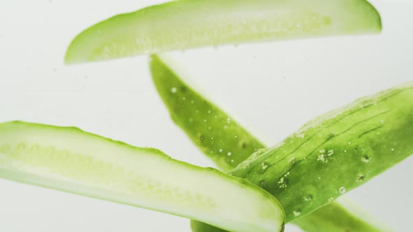 Fresh Cucumber Falling Into The Water In White Background. - close up, slow motion alt