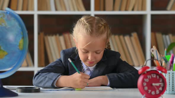 girl sitting at a table doing homework alt