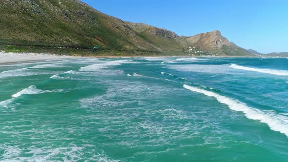 Aerial Shot Slowly Tracking in Toward a Kiteboarder Riding His Way Out to Shore