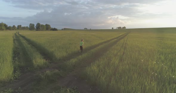 Sporty Child Runs Through a Green Wheat Field alt