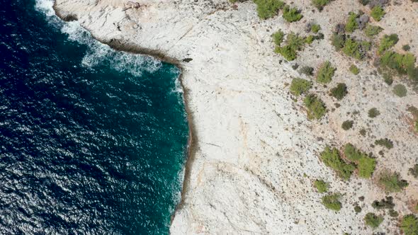 Drone Flying Along Rocky Coast Line and Dreep Blue Sea Water alt