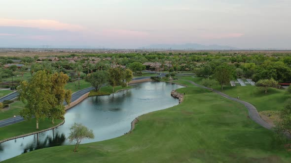 Stunning overhead aerial of a beautiful golf course, lake and luxury resort homes. alt
