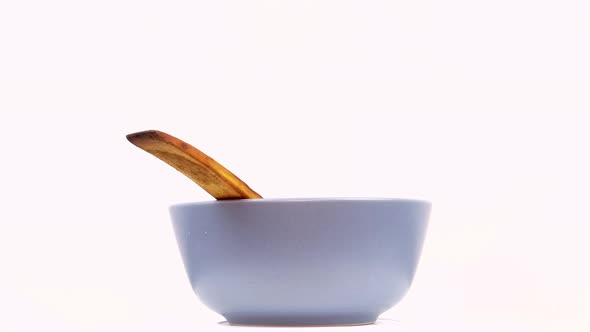 Ceramic plate with wooden spoon on a white background.