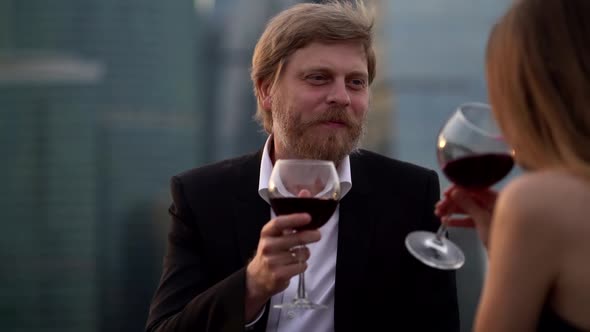 Middle Aged Man and Young Sexy Woman Are Meeting at Party, Communicating and Drinking Red Wine alt