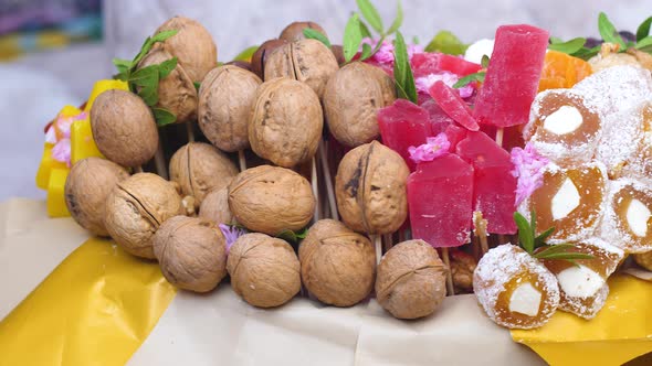 Close-up of a sweet edible bouquet collected from walnuts, marshmallow, figs, dried fruits, prunes,  alt