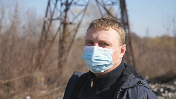 Portrait of Man with Medical Face Mask Stands at City Street During COVID-19 Epidemic. Guy Wearing alt