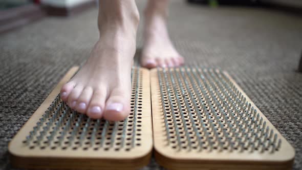 Woman Stepping on Wooden Board with Sharp Metal Nails Sadhu Yoga Board Foot Relaxation Acuupuncture alt