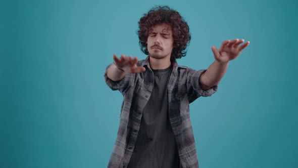 The Focused Young Man Closes His Eyes and Stretches Out His Hands to Find What He is Looking for alt