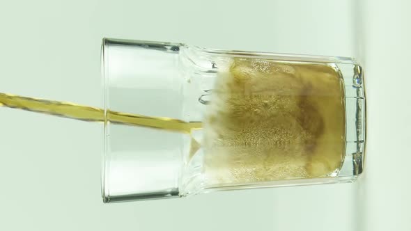 Vertical Video Cola is Poured Into Faceted Glass Full of Bubbles and Foam Isolated on White