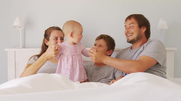 Happy Family with Cute Little Kids Son Daughter Tickling Having Fun Relax on Bad Together Young alt