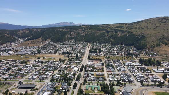 Jib down lowering over Esquel town with Andean mountains in background, Patagonia Argentina alt