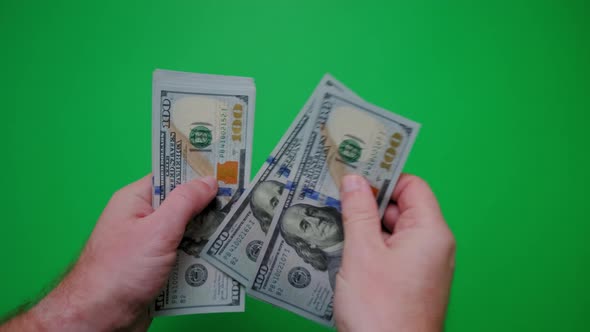 Count of Money From Hand to Hand on a Green Background alt