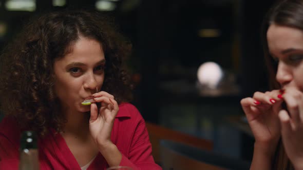 Beautiful Ladies Eating Lemon After Drinking in Bar alt