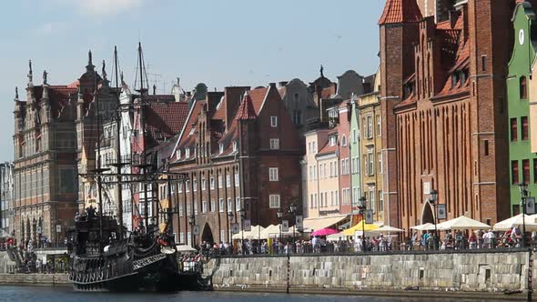 Riverside of Historical Town with Old Vessel on River, People Go Sightseeing alt