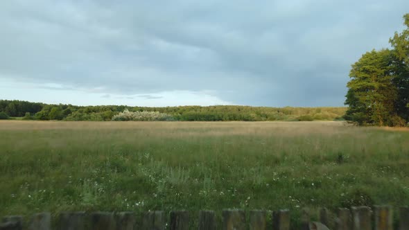 Flight Over An Old Wooden Fence. Along A Grassy Meadow. At A Low Altitude. Aerial Photography. alt