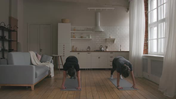 Man and Woman Practicing Yoga at home