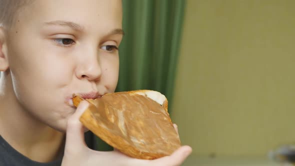 Girl Teenager High School Student with Short Hair Eats a Sandwich with Chocolate