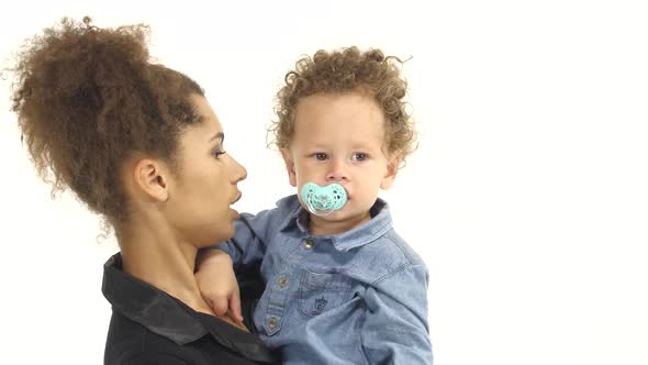 African American Mother Is Shaking a Small Child in Her Arms. White Background alt