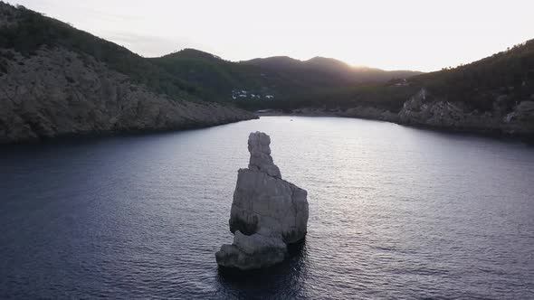 Smooth drone traveling shot passing close to Benirrás rock before sunrise in November. No boats neit alt