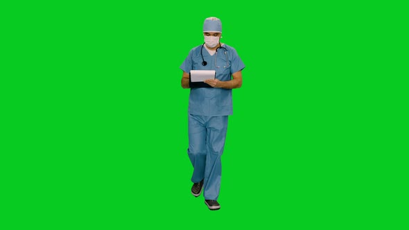 Doctor in Mask and Uniform Writing on Clipboard while Walking on Green Screen 